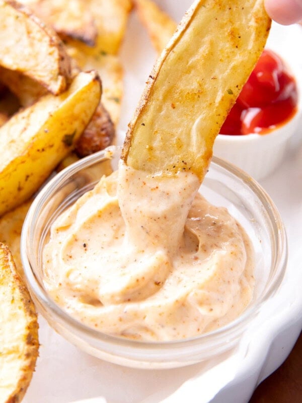 Dipping a potato wedge into chipotle aioli