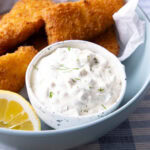 This tartar sauce is thick and creamy served in a dip bowl with fried fish sticks and a lemon wedge