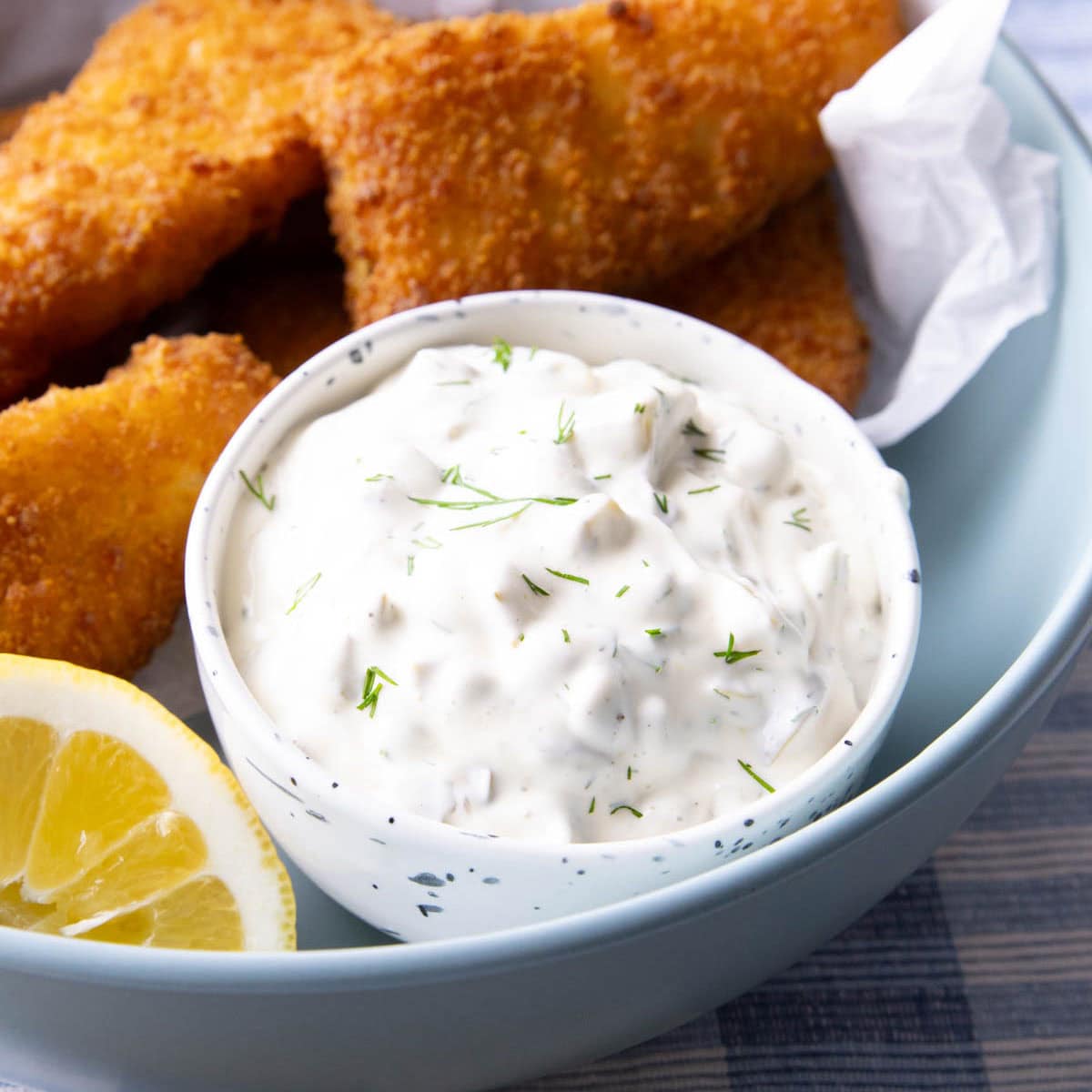 This tartar sauce is thick and creamy served in a dip bowl with fried fish sticks and a lemon wedge