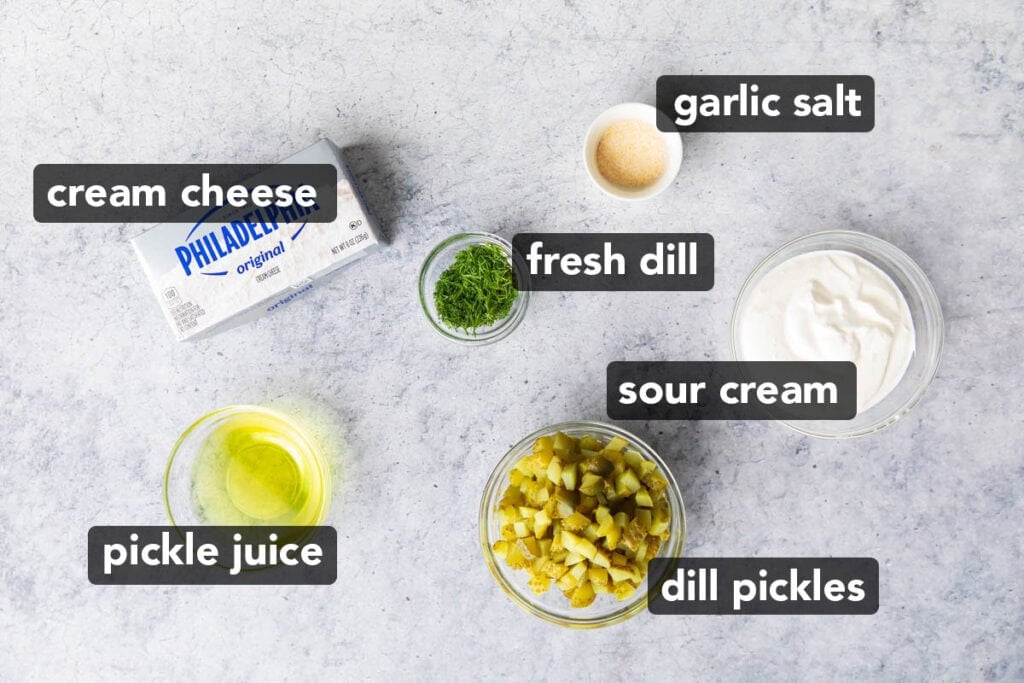 Dill pickle dip ingredients including cream cheese, dill, dill pickles, sour cream, pickle juice, and garlic salt
