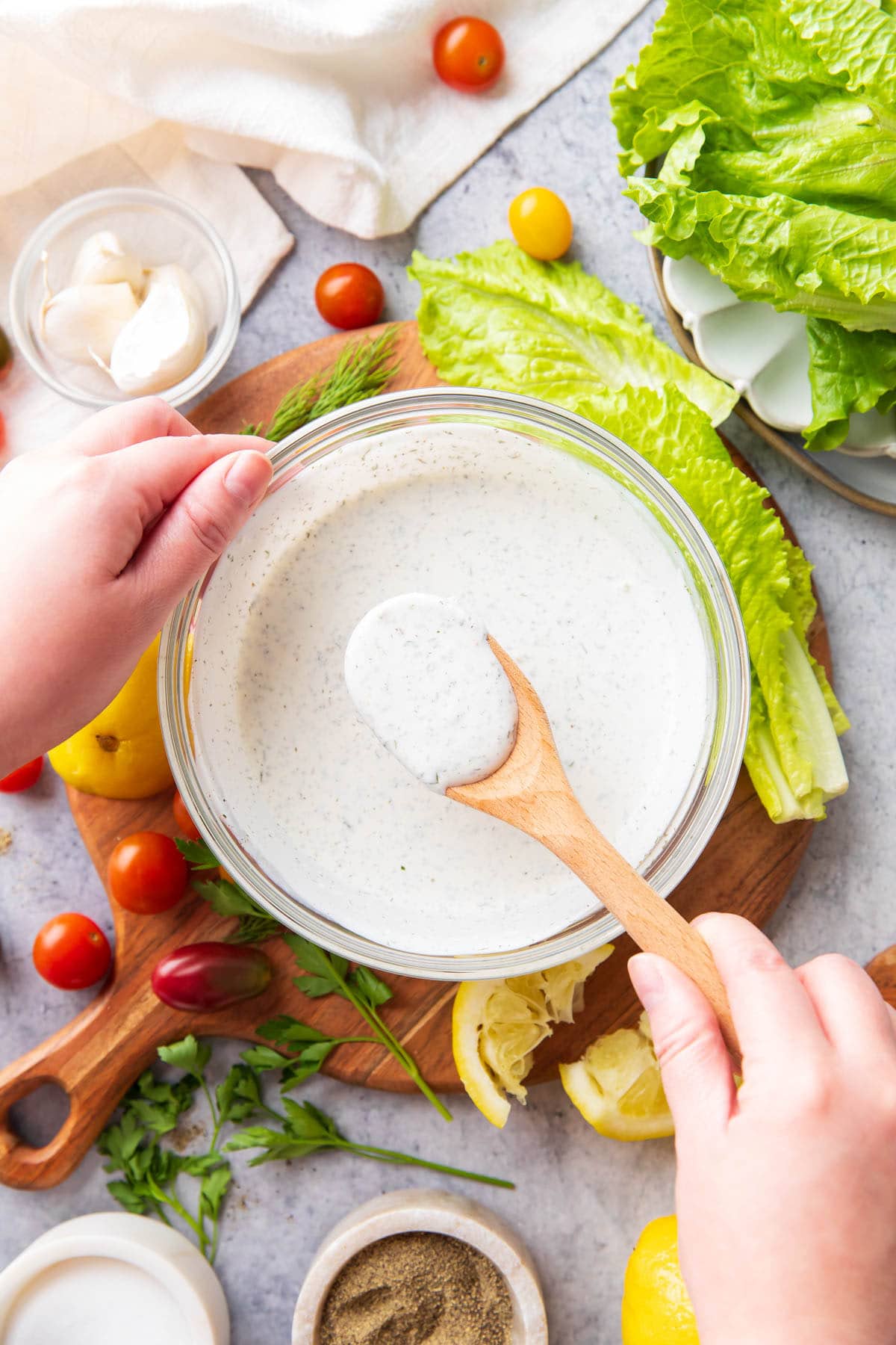 Holding a spoon full of thick and creamy ranch dressing packed full of delicious herbs and seasonings