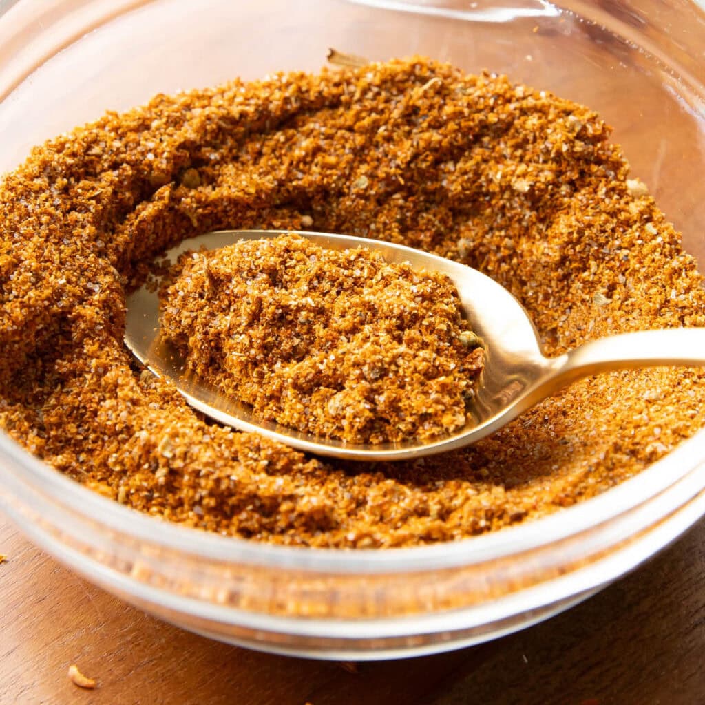 A bowl of taco seasoning with a spoon in it