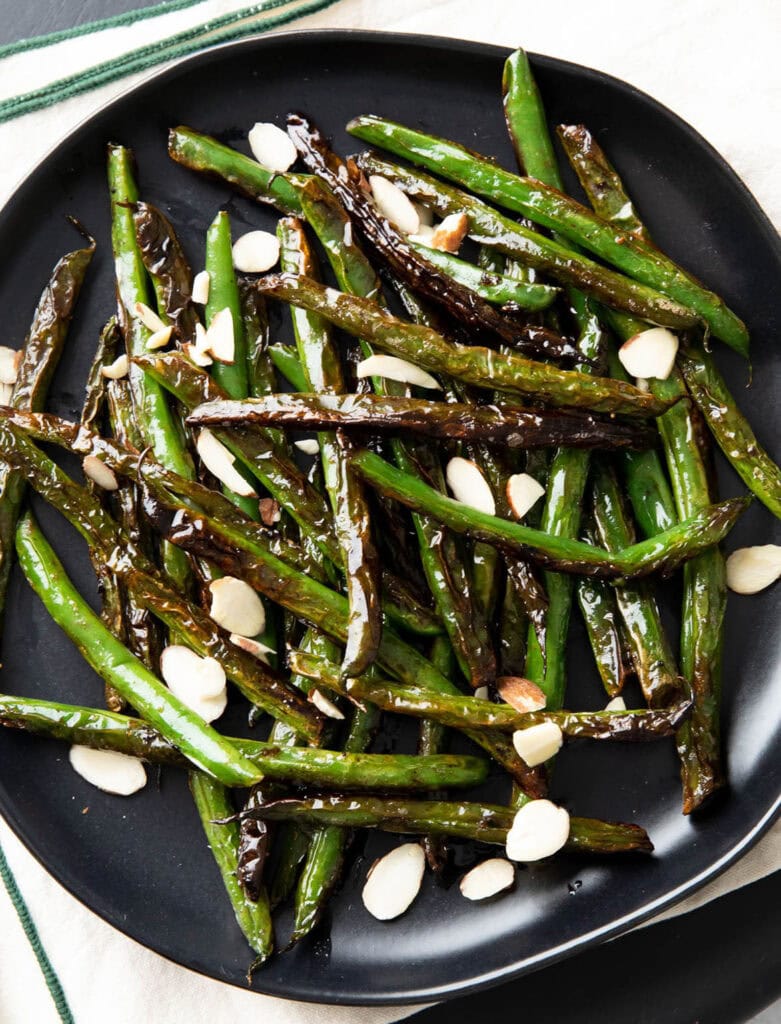 Side Dishes photo featuring blistered green beans served up with charred edges and topped with almonds