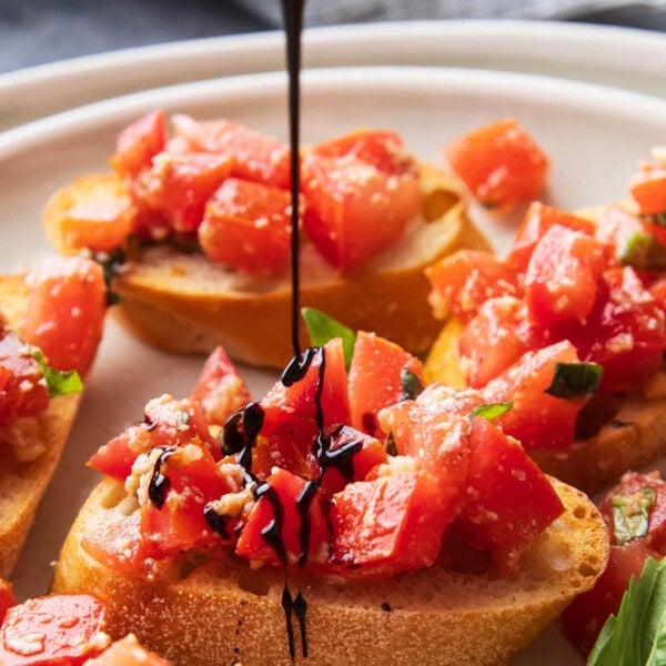 Drizzling balsamic glaze over this classic Italian antipasto, bruschetta, packed with tomatoes and basil atop toasted olive oil baguettes.