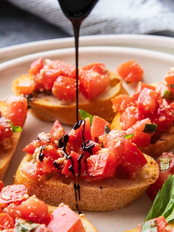 Drizzling balsamic glaze over this classic Italian antipasto, bruschetta, packed with tomatoes and basil atop toasted olive oil baguettes.