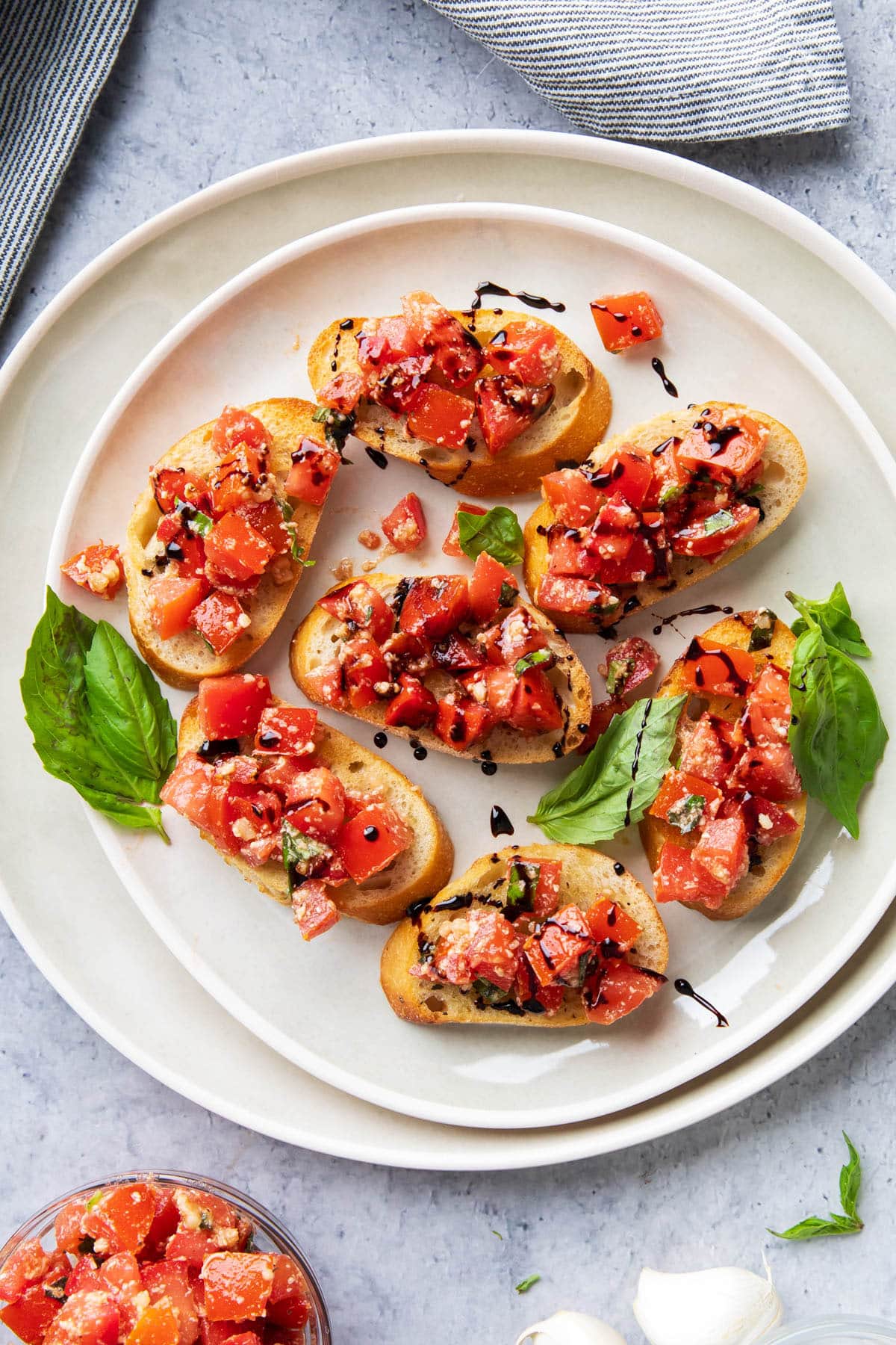 Platter of this Italian antipasto on toasted, sliced baguettes topped with tomato, basil, parmesan, and Italian seasoned topping with olive oil.