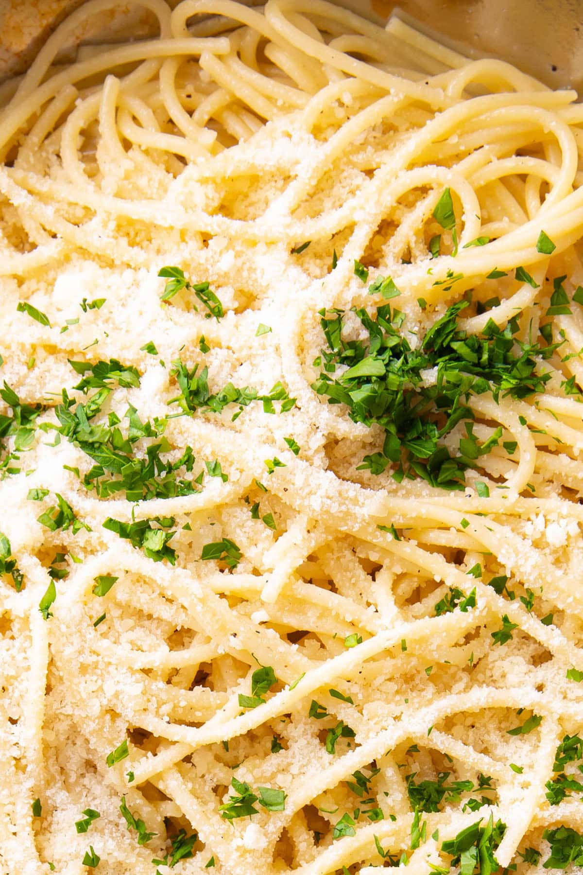 Close up of buttery, perfectly cooked Garlic Butter Pasta topped with parsley and parmesan