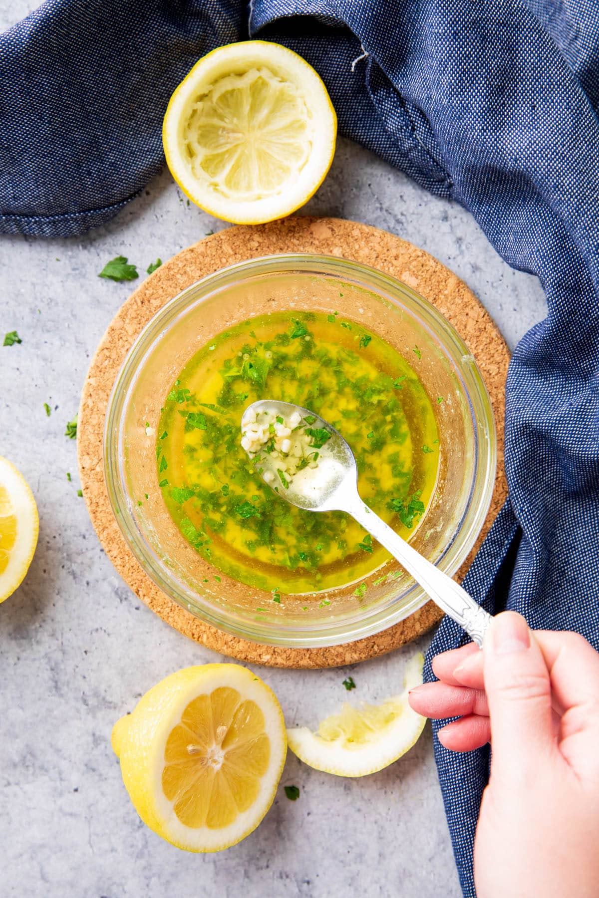 Spooning garlic butter sauce over a bowl with melted, fragrant garlic, parsley, and seasonings