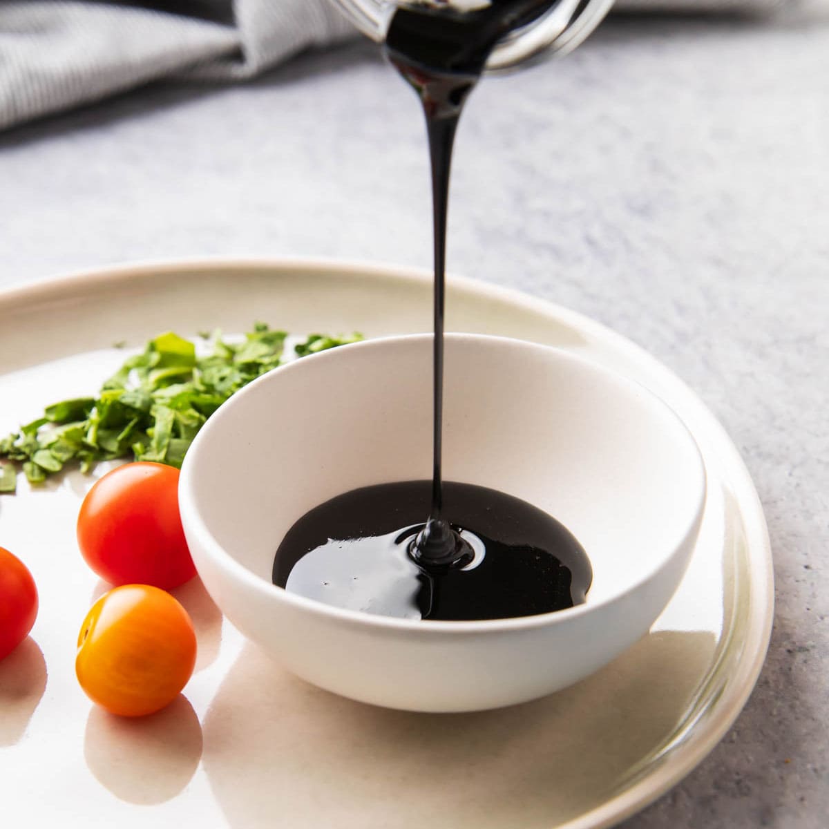 pouring balsamic glaze into a bowl to show the thickness