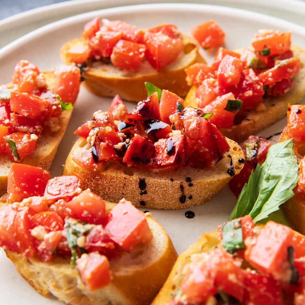 close up of bruschetta on toasted bread with a drizzle of balsamic glaze