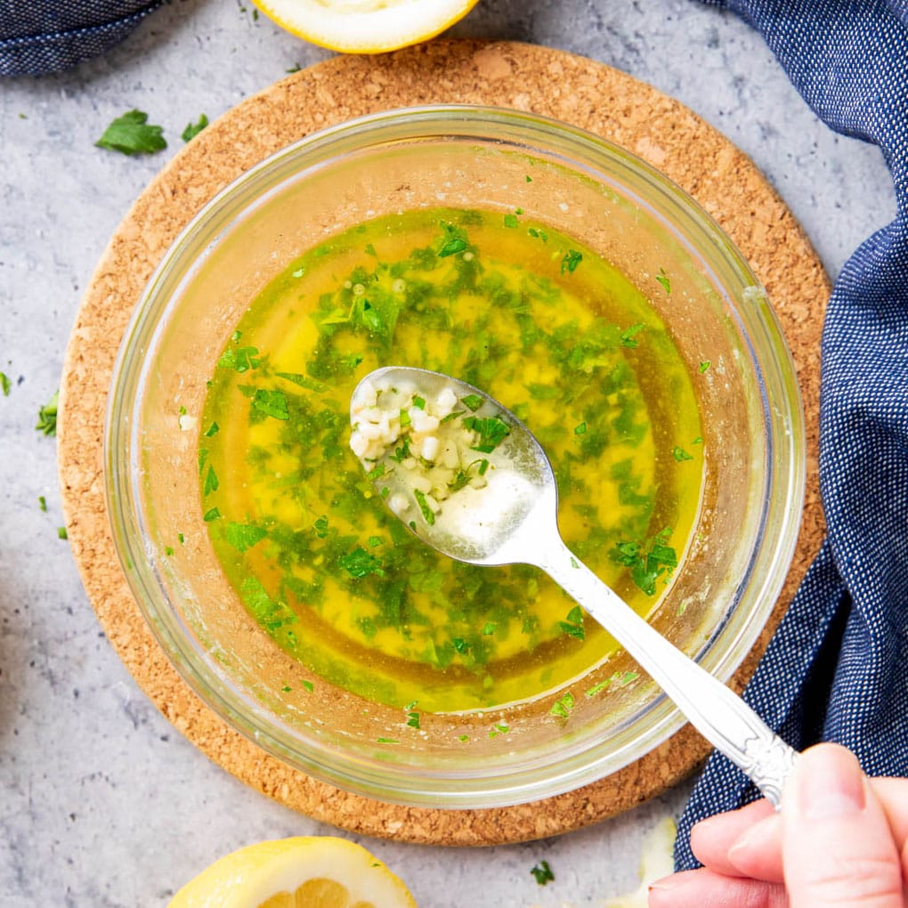 bowl filled with fresh, homemade garlic butter sauce with a spoon