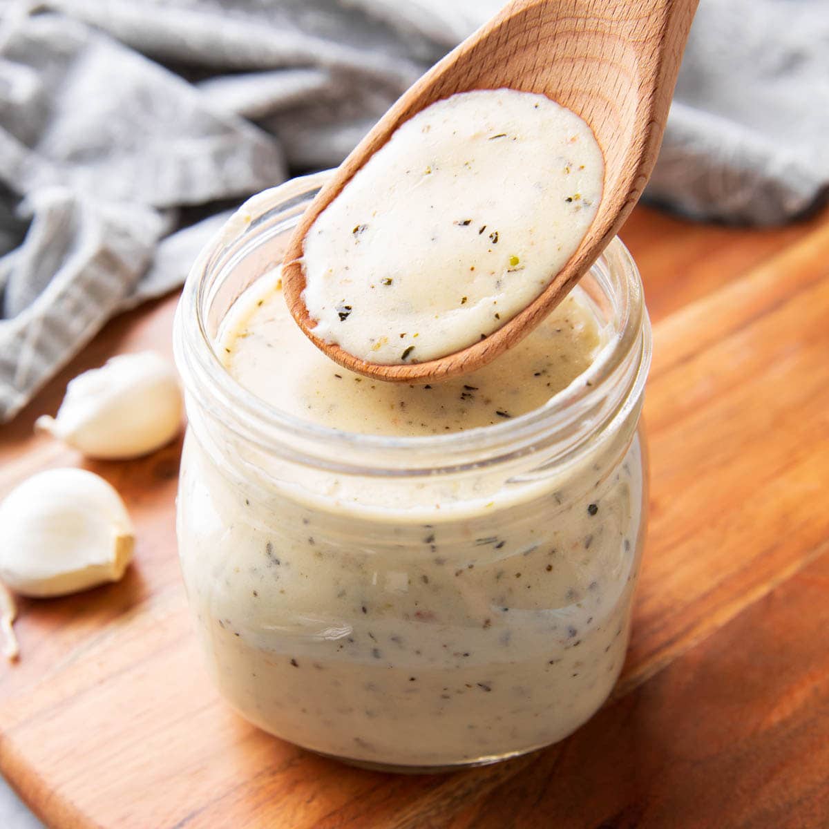 jar filled with creamy, rich garlic parmesan sauce thickened with cheese and herbs
