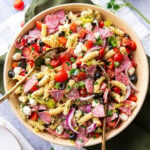 A serving bowl filled with Italian Pasta Salad packed with tomatoes, mozzarella, and Italian dressing.