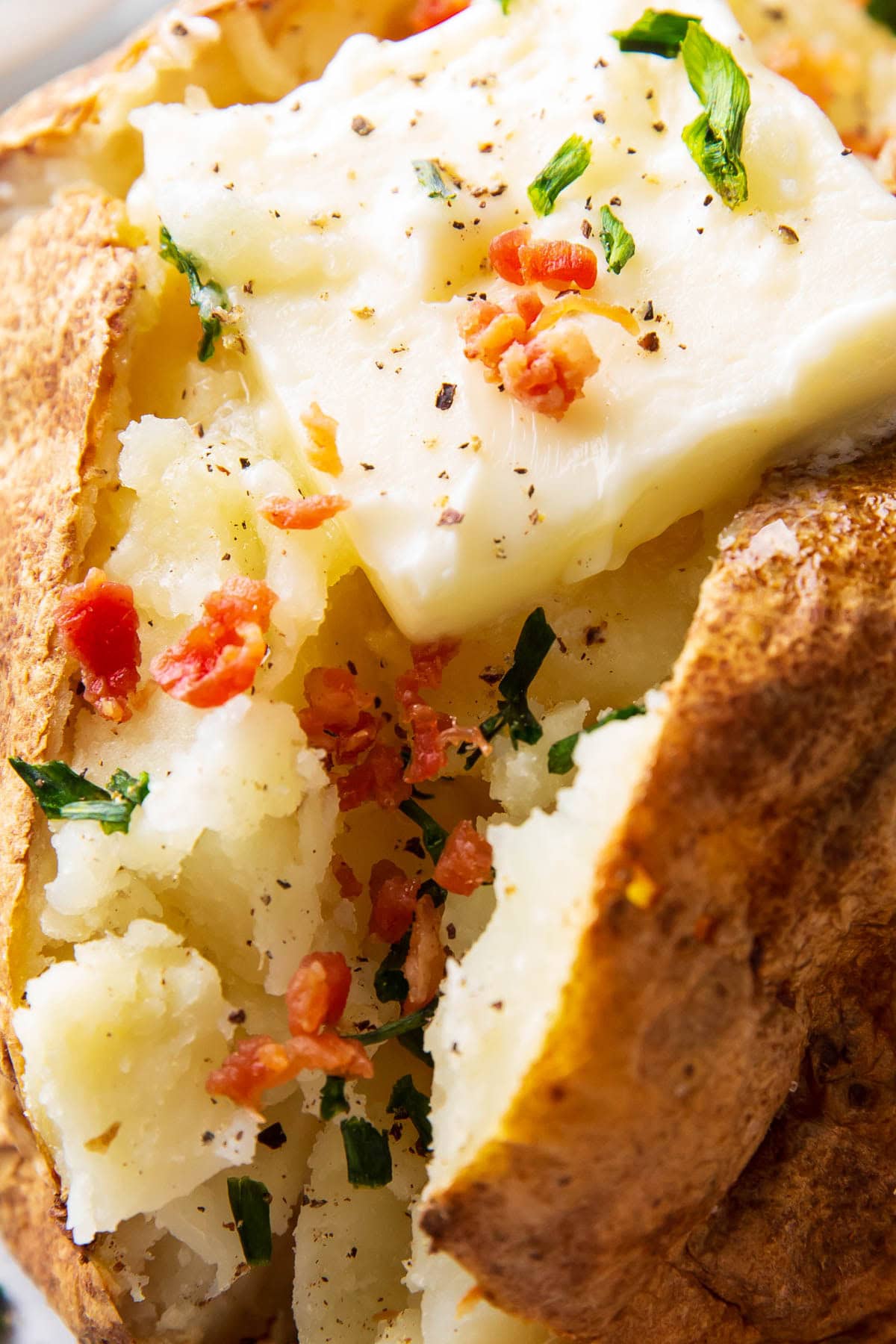 Close up of baked potato in air fryer to show soft center and crisp skin