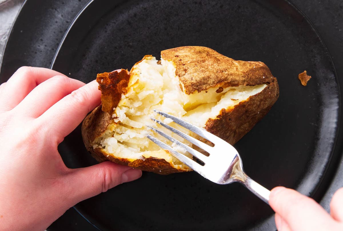 A showing how to split one open - using a fork to mash and fluff up the center