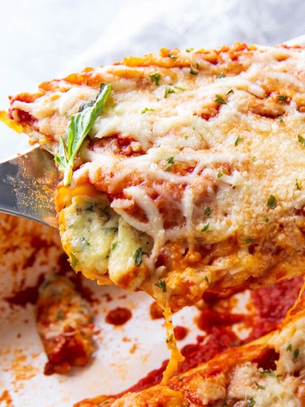 Close up of a spatula full of this easy manicotti recipe stuffed with ricotta cheese.