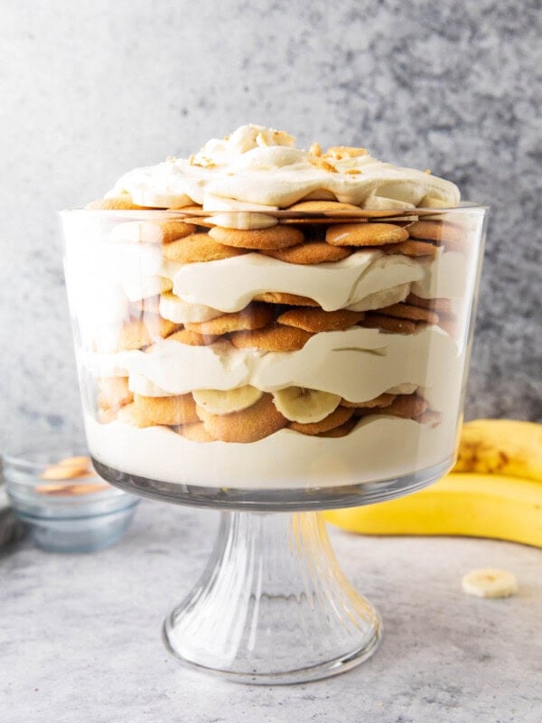 Ripe bananas, crunchy vanilla wafers, and whipped topping mixed with instant pudding mix layered in a glass bowl for this simple banana pudding recipe.