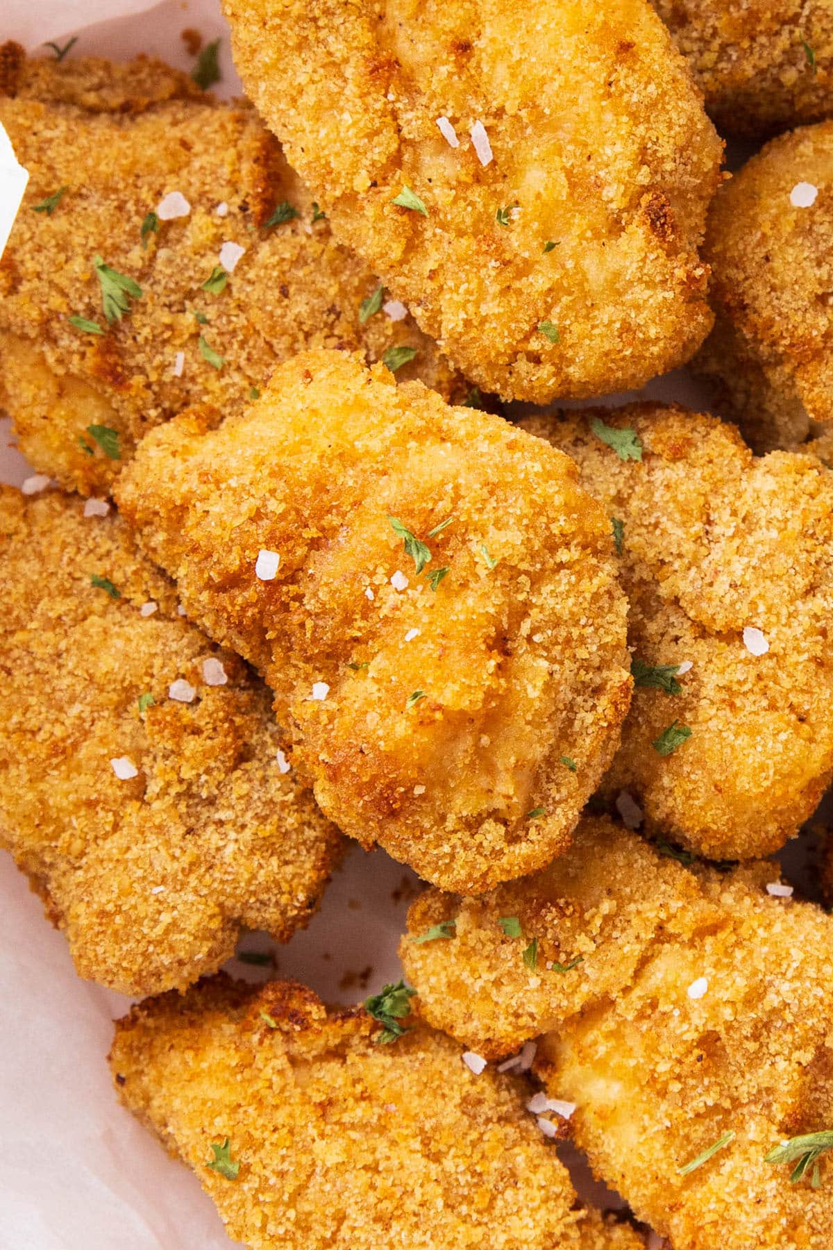 Close up to show crisp exterior and juicy, tender centers of air fryer chicken nuggets