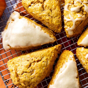 Close up of the flaky, cracked tops of fresh-baked pumpkin scones with maple glaze