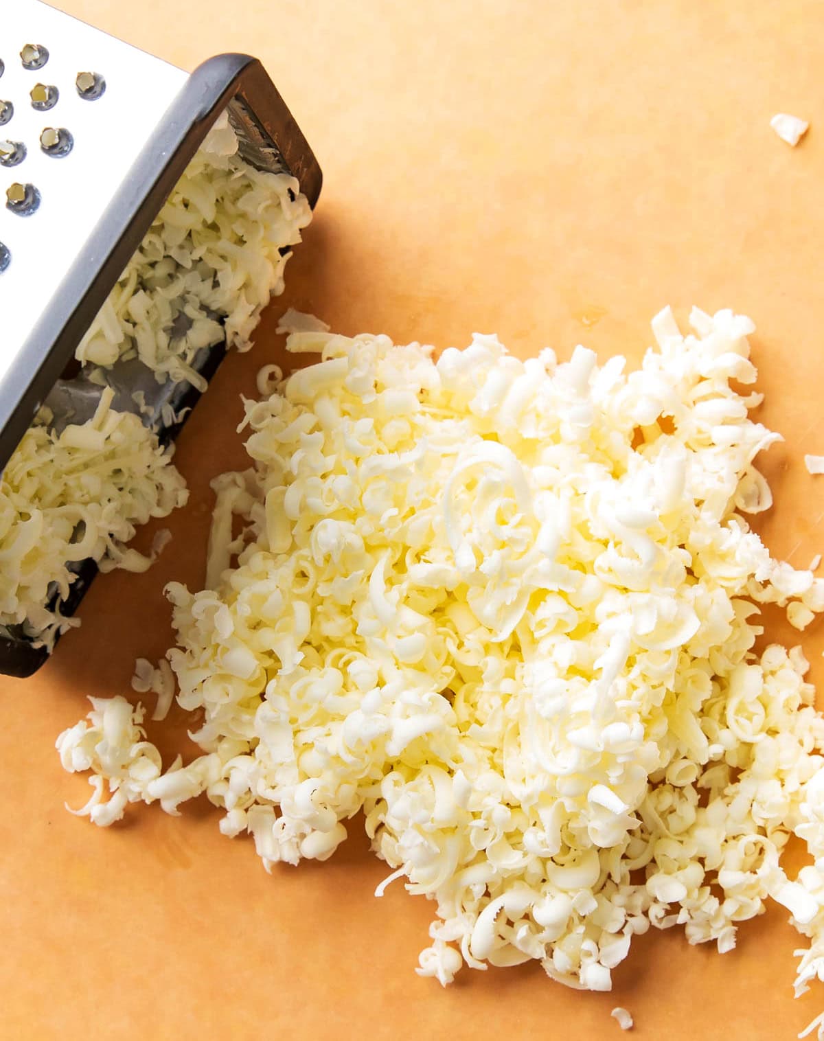 A photo showing How to Make Pumpkin Scones - close up of grated frozen butter to show thickness