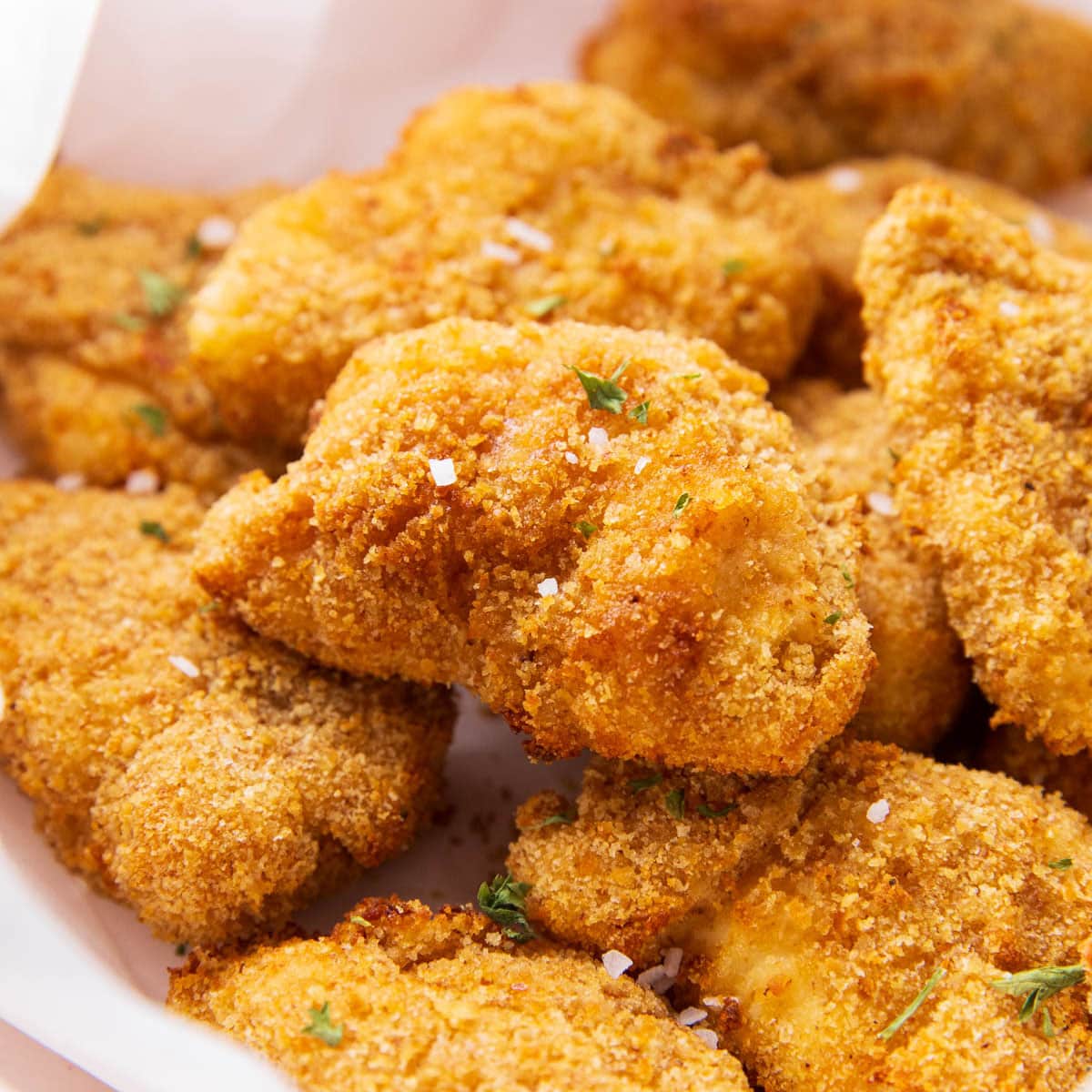 featured image with air fryer chicken nuggets in a basket with salt and seasonings