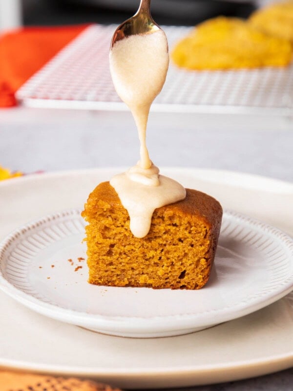 Spoon drizzling onto Pumpkin Cake - drizzling this sweet maple glaze thickly over a dessert