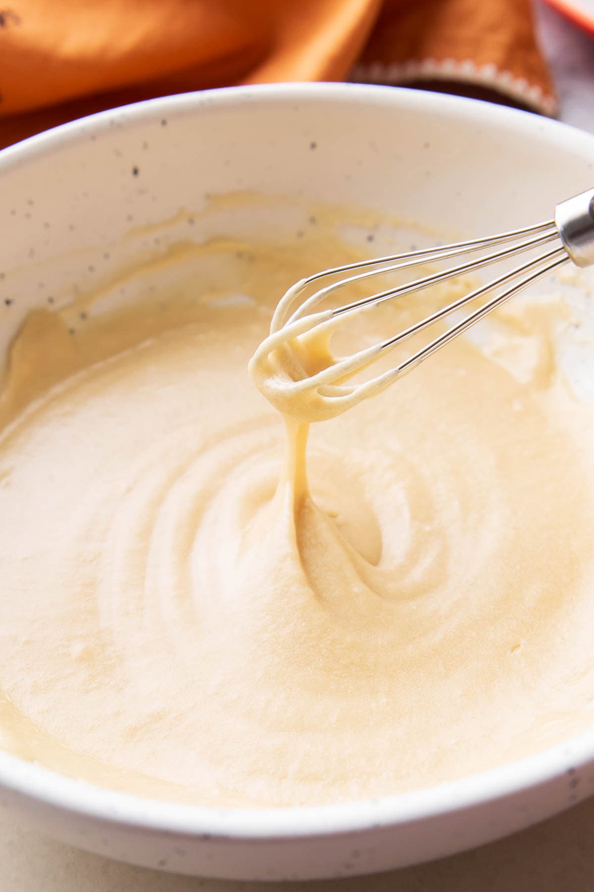 Tiny Whisk Angled - Maple glaze dripping from a whisk is ready to glaze donuts, cakes, and more.