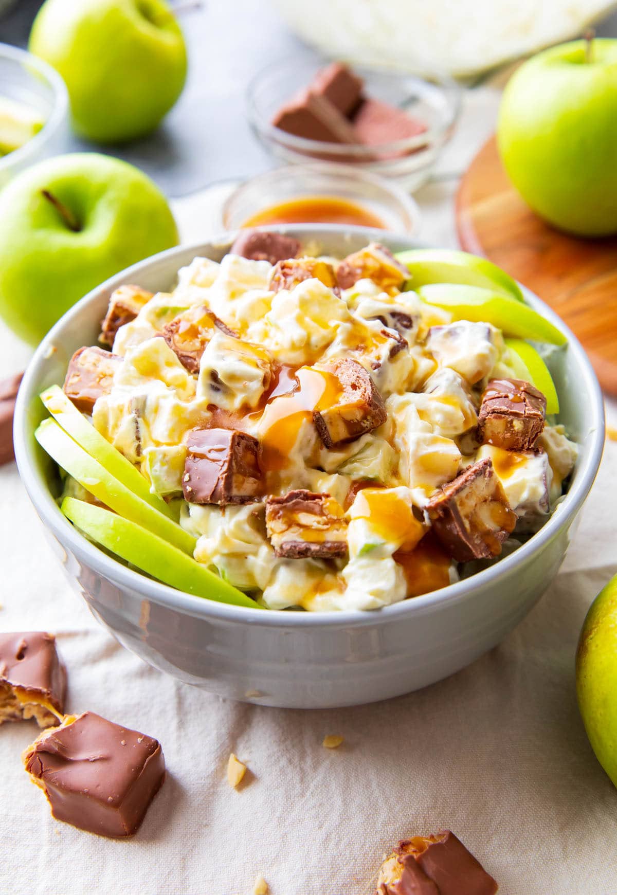 Serving bowl filled with creamy Snickers Salad topped with caramel