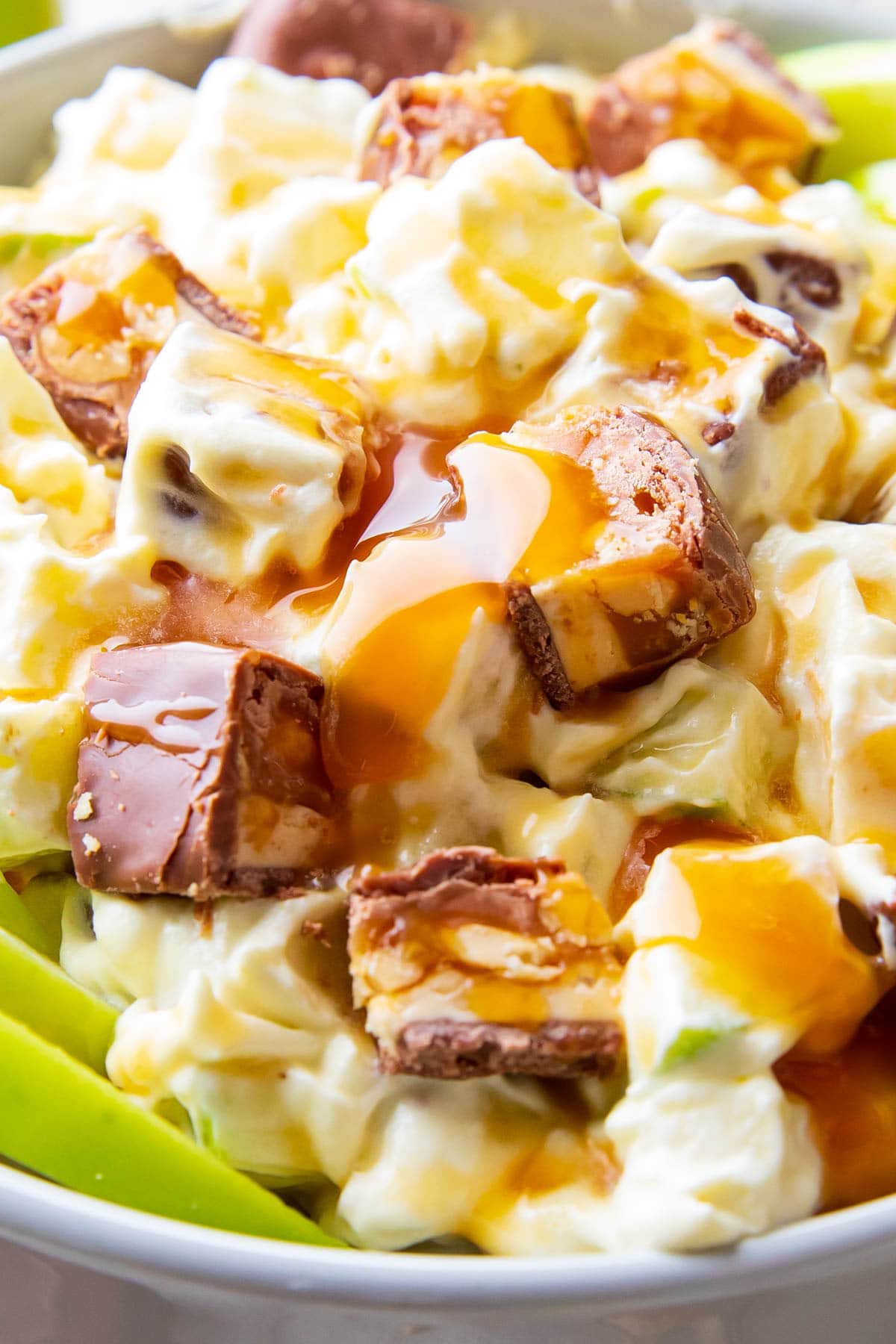 close up to show abundance of snickers, caramel sauce, apples, and creamy dressing for this dessert salad