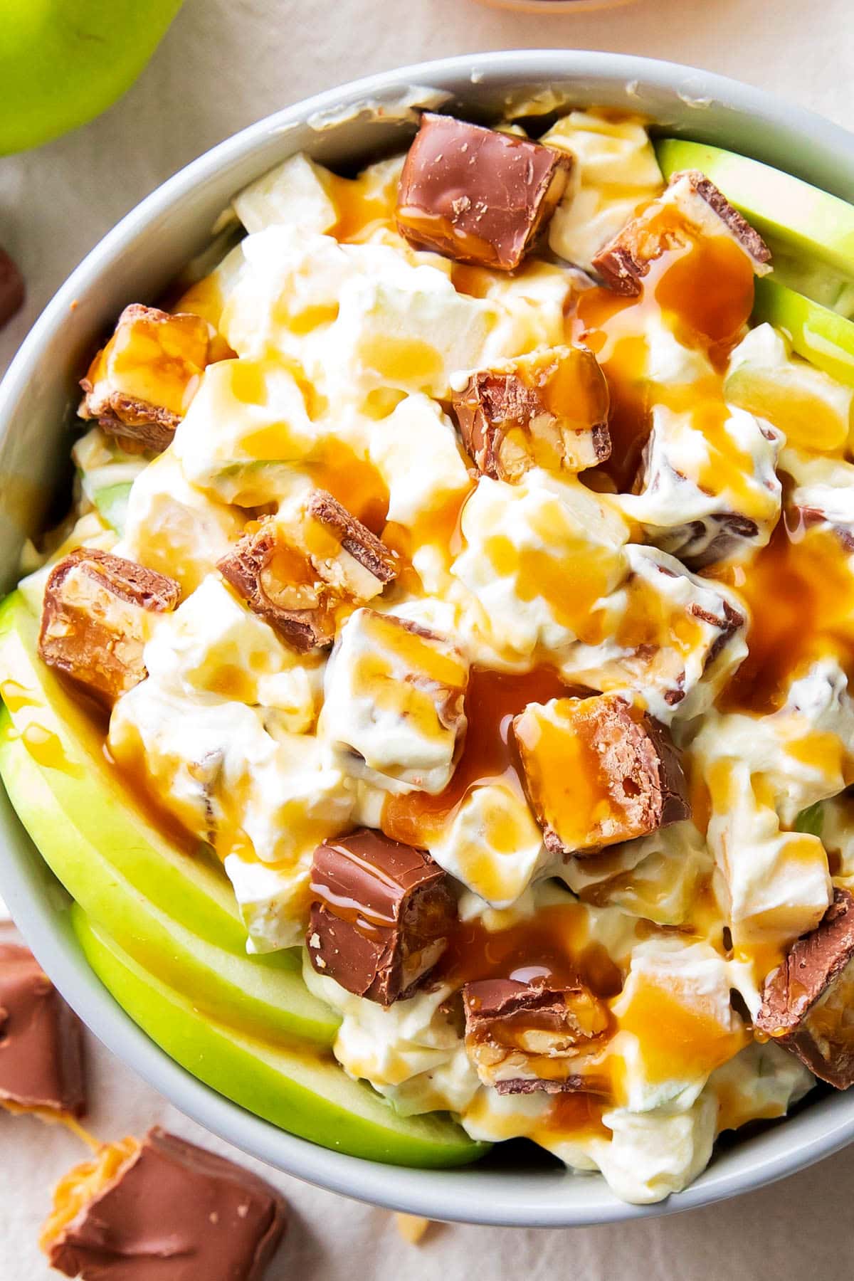 Close up of Snickers Salad with cream cheese dressing made with vanilla pudding and Cool Whip.