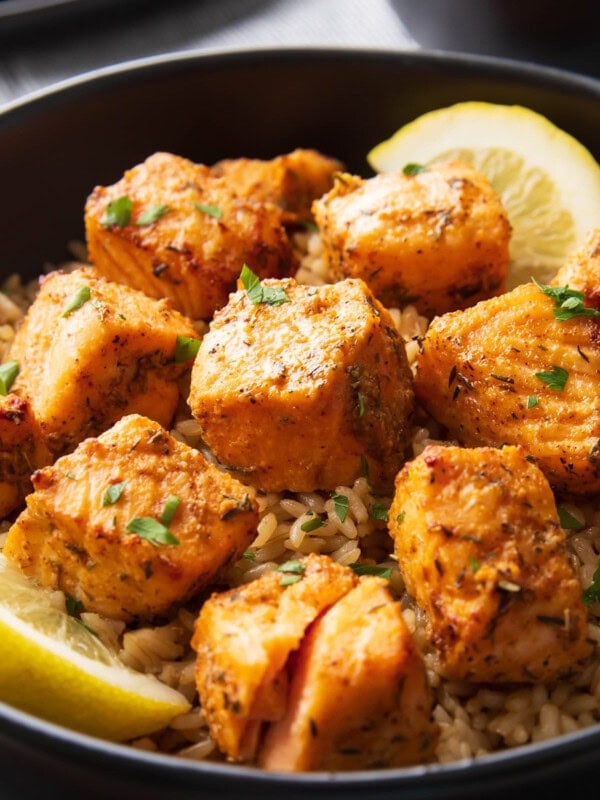 Close up of Air Fryer Salmon bites served with rice and lemon wedges.