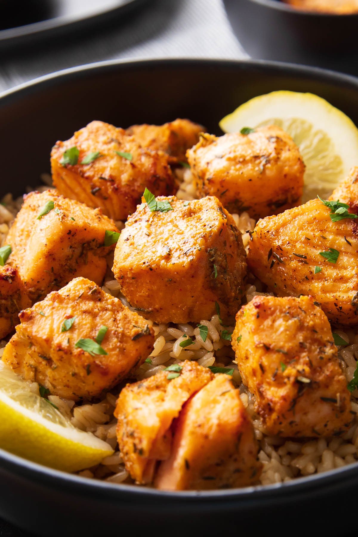 Close up of Air Fryer Salmon bites served with rice and lemon wedges.