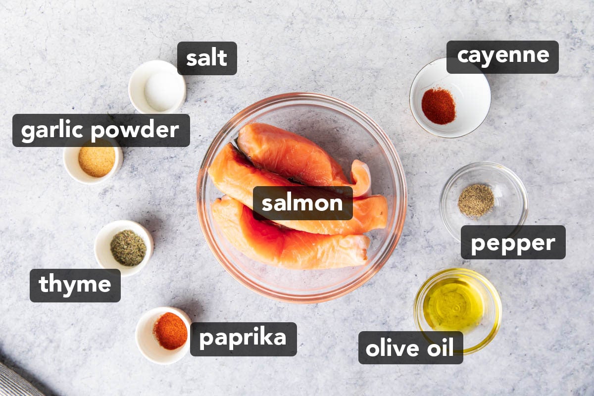 Easy Air Fryer Salmon Bites ingredients in mis en place including salmon fillets, spices, and oil.