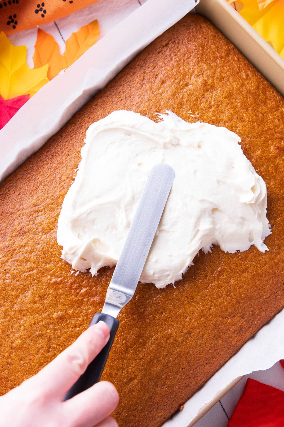 Frosting Pumpkin Cake w Offset Spatula - using an offset spatula to spread this cream cheese frosting recipe on top of a pan of pumpkin cake