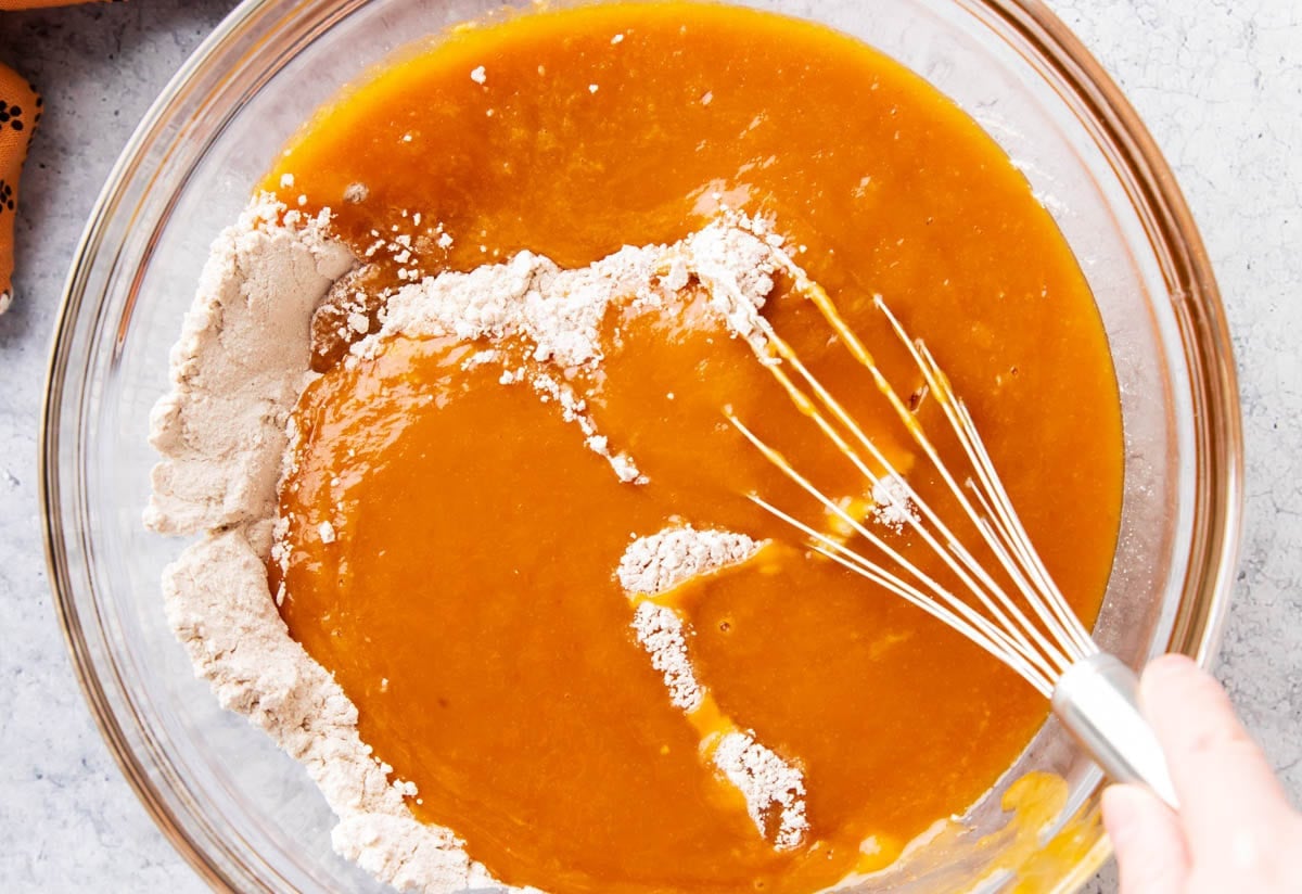 Combining wet and dry ingredients to make pumpkin cake batter.
