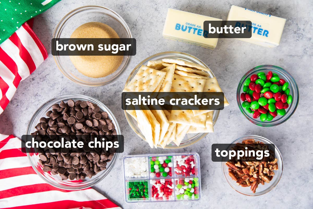 Easy Christmas Crack recipe ingredients including butter, brown sugar, chocolate chips, saltine crackers, and toppings like sprinkles, candy, and nuts