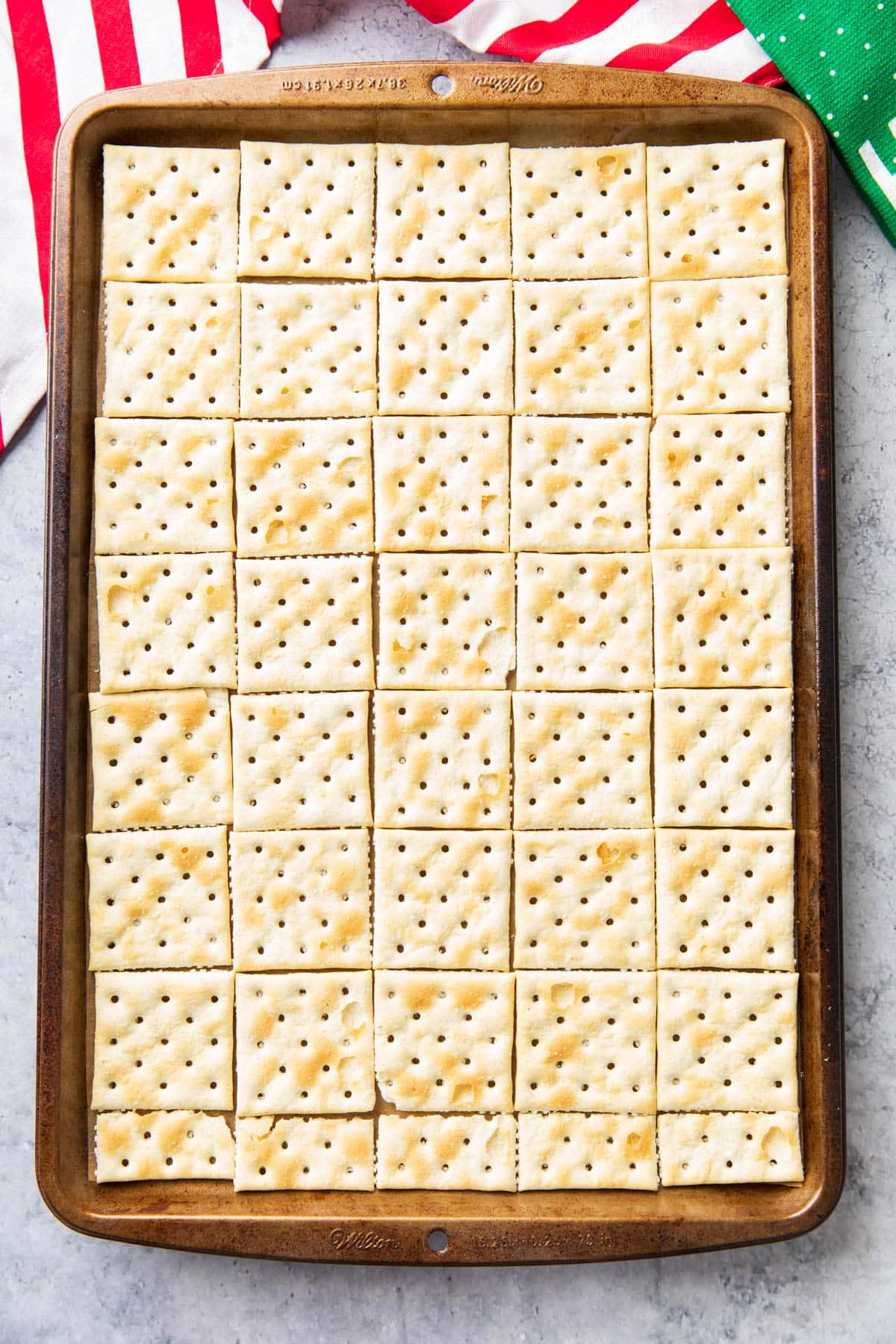 A single layer of saltine crackers laid out on a baking sheet