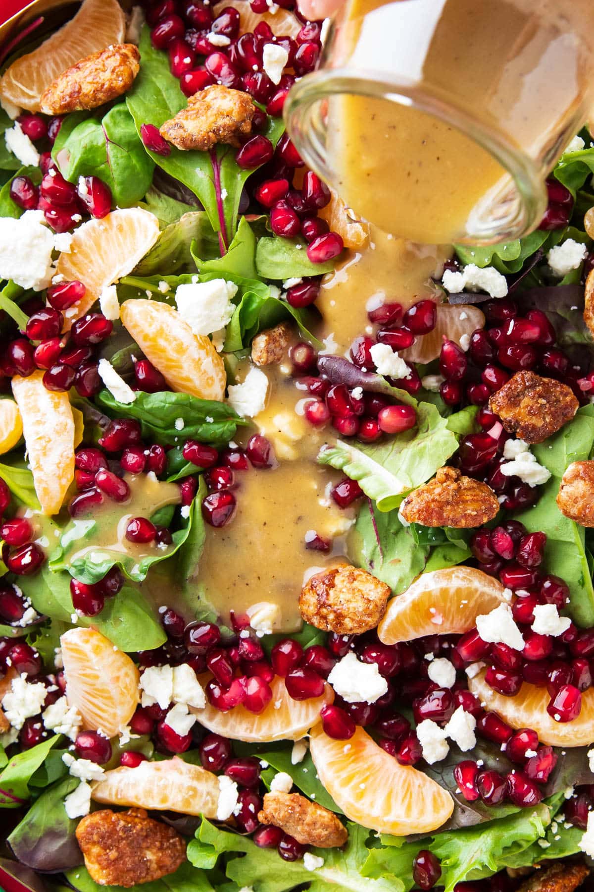 Pouring honey mustard dressing over this Christmas Salad recipe.