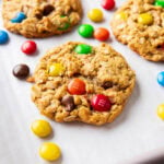 angled photo of monster cookies with chewy oat texture, dotted with colorful M&M’s candies and chocolate chips.