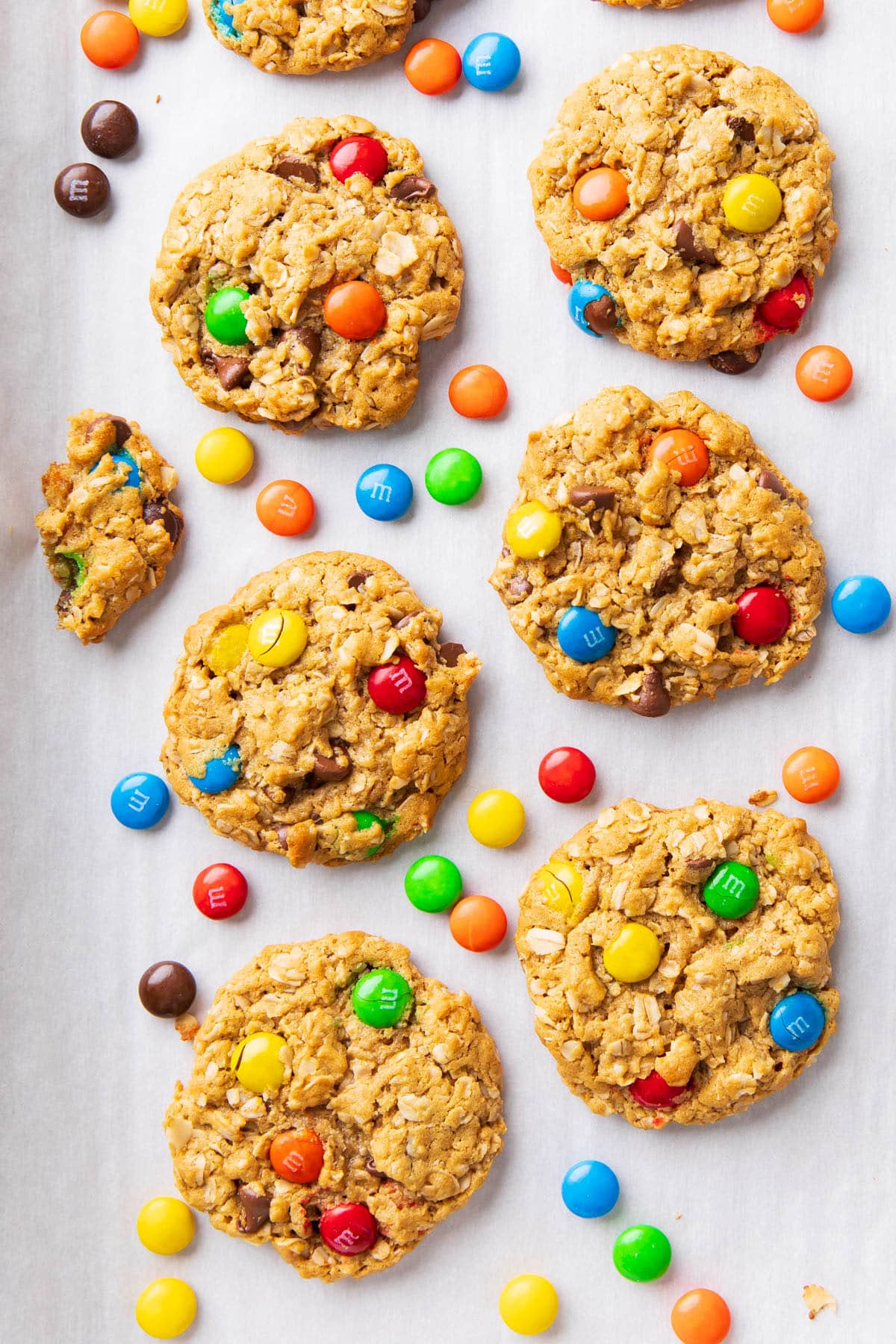 Rows of the best monster cookie recipe cooling on a parchment-paper lined baking sheet.