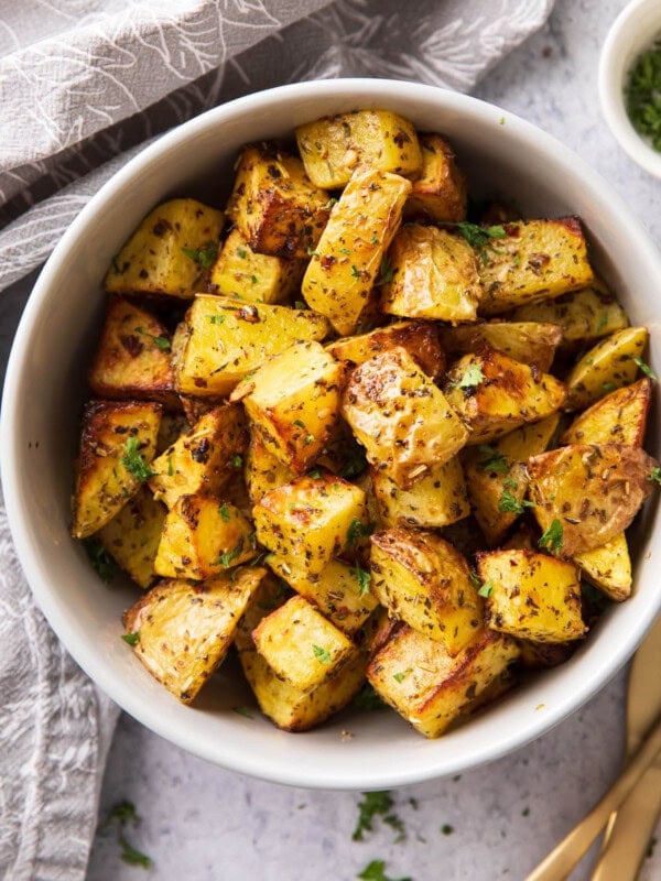 Air Fryer roasted potatoes in a serving bowl topped with seasoning and crisped edges