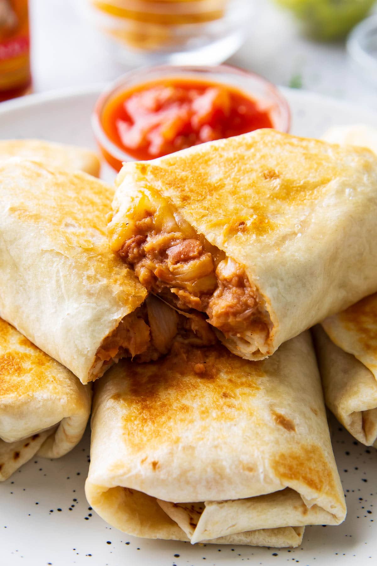 Close up of half of a bean and cheese burrito with refried beans and cheese oozing out.