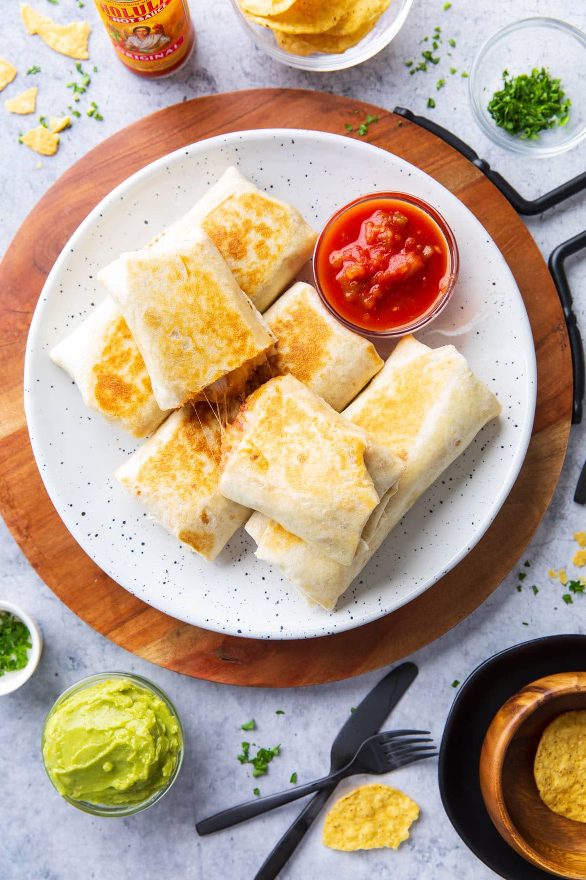 A full table set with this easy homemade recipe served on a platter with salsa, guacamole, green onions, and cheese.