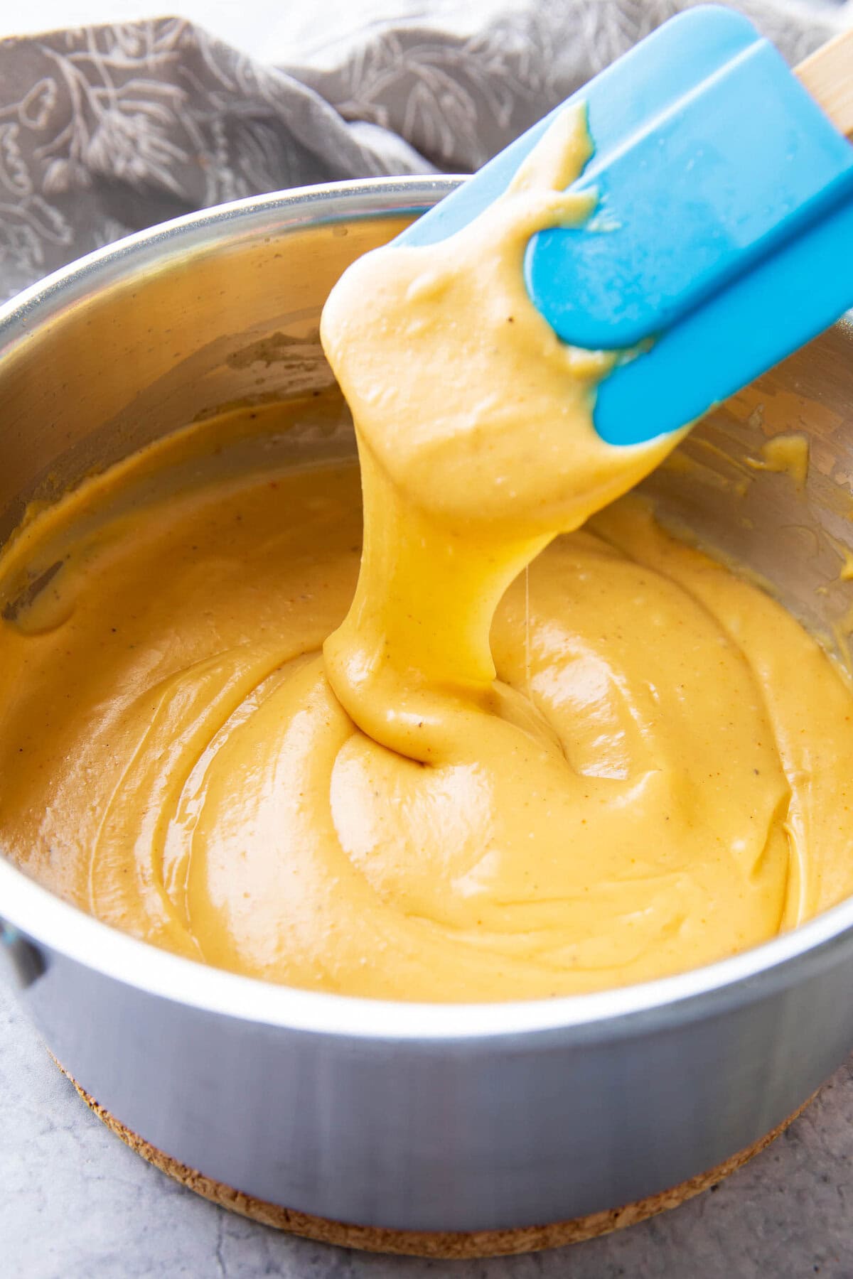 a spatula scooping up this thick and creamy sauce dip to showcase texture.