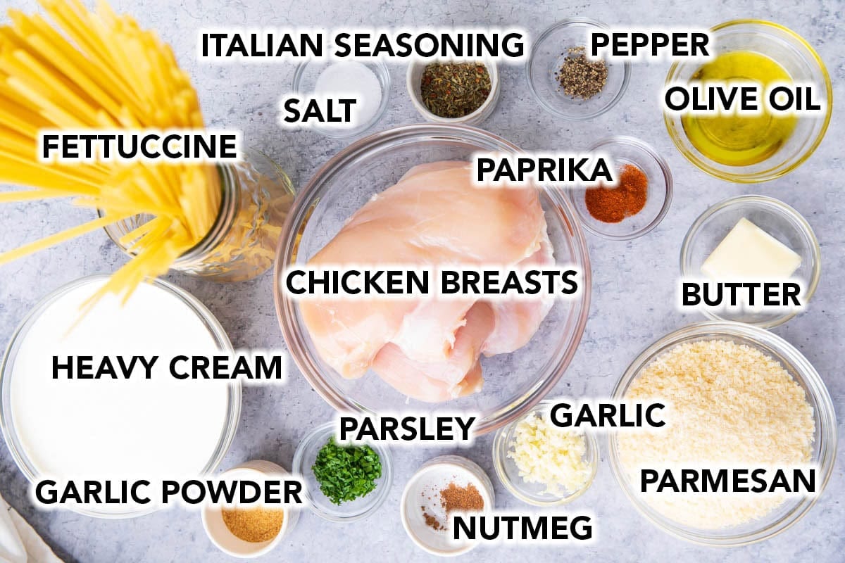 Chicken fettuccine Alfredo recipe ingredients in prep bowls including pasta, chicken breasts, Italian seasoning, parmesan cheese, heavy cream, garlic powder and more.