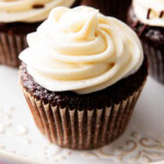 close up of thick, creamy cream cheese frosting on top of a chocolate cupcake.