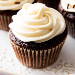 close up of thick, creamy cream cheese frosting on top of a chocolate cupcake.