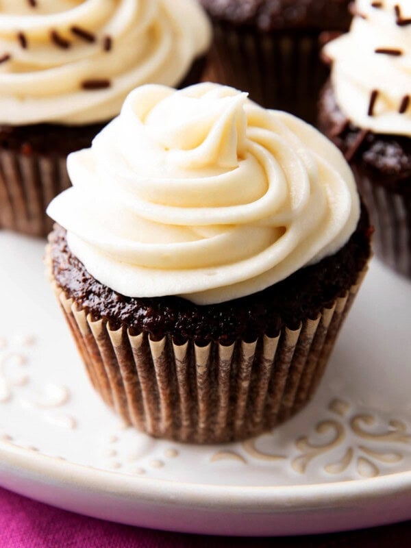 close up of thick, creamy cream cheese frosting on top of a chocolate cupcake.