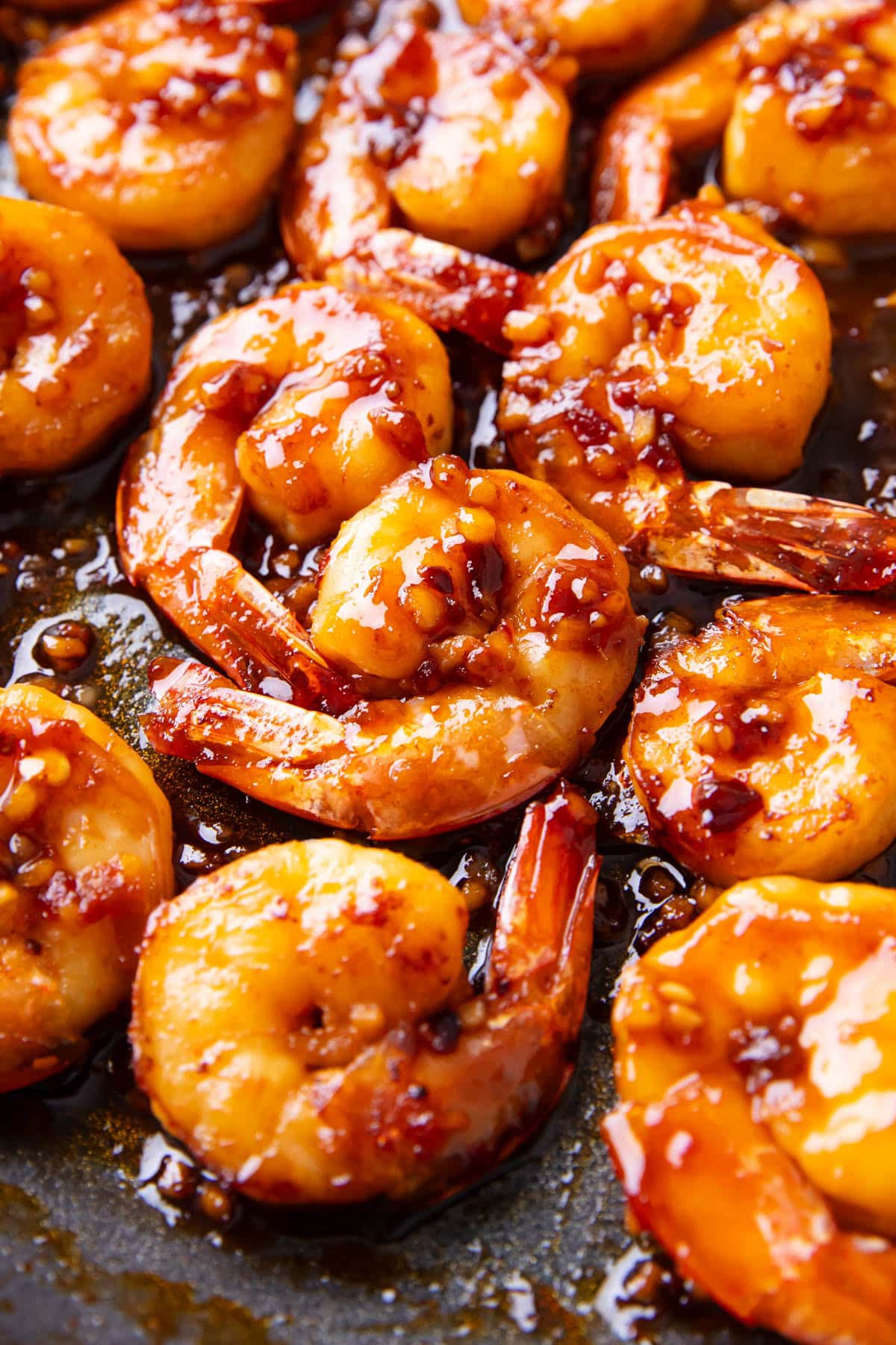 Close up of Asian garlic shrimp coated in a spicy and sweet Asian sauce packed with minced garlic, ginger, sriracha, chili oil, and sesame oil.