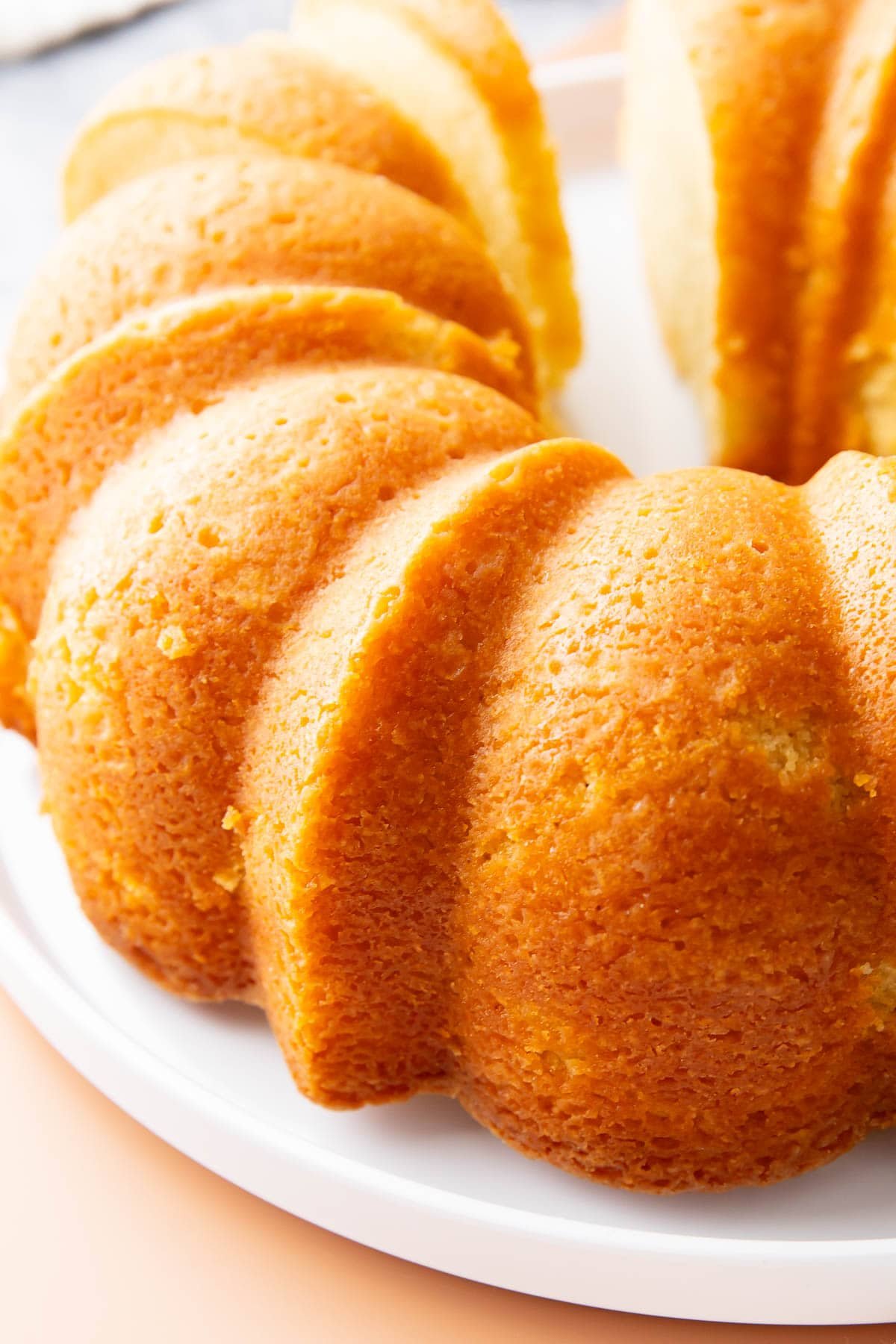 Old fashioned buttermilk pound cake has a golden brown exterior with tender, moist crumb inside due to a combination of flour, cardamom, baking soda, butter, sugar, 5 large eggs, vanilla, and room temperature buttermilk.
